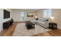 Bright living room features a comfortable sectional sofa, a modern TV console, and stylish decor at 5402 Carr St # 307, Arvada, CO 80002
