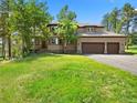 Beautiful home featuring a three-car garage and a well-manicured lawn at 7197 Timbers Dr, Evergreen, CO 80439