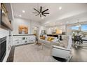 Bright living room with a fireplace, ceiling fan, built-in shelves, and view of the adjacent kitchen at 15156 W Baker Pl, Lakewood, CO 80228