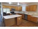 Bright kitchen featuring stainless steel appliances, wooden cabinetry, and an island with a white countertop at 2517 S Genoa St, Aurora, CO 80013