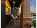 Inviting front porch features a cozy swing and stone pillars, perfect for relaxation at 3636 Sublime Ct, Castle Rock, CO 80108