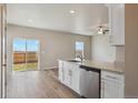 Bright kitchen with white cabinets, quartz countertops, and sliding glass doors at 48280 Shetland Dr, Bennett, CO 80102