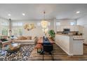 Open-concept living room with wood floors, modern chandelier, and lots of natural light at 10179 Cherryhurst Ln, Highlands Ranch, CO 80126