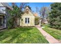 Inviting front yard showcases a cozy home with lush lawn and a stone path to the entrance at 3333 W Hayward Pl, Denver, CO 80211