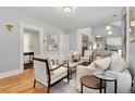Bright living room with hardwood floors, neutral decor, and an open layout connecting to the kitchen at 3333 W Hayward Pl, Denver, CO 80211