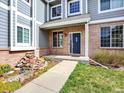 Inviting front entrance with a blue door, brick accents, and a charming rock garden at 6094 Terry Ln, Arvada, CO 80403