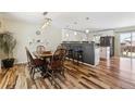 Bright dining room leads into the kitchen, complemented by wood floors and modern lighting at 4879 S Xenophon St, Morrison, CO 80465