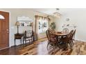 Sunlit dining room features wood floors, a stylish light fixture, and elegant furnishings at 4879 S Xenophon St, Morrison, CO 80465