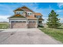 Spacious home featuring a three-car garage and inviting front porch at 40900 Red Fox Cir, Elizabeth, CO 80107