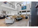 An expansive living room with ample seating and great natural light from the oversized windows at 7077 Copper Sky Cir, Castle Pines, CO 80108