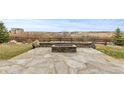 Stone patio with a built-in fire pit offers a cozy outdoor space and scenic views of the natural landscape at 7077 Copper Sky Cir, Castle Pines, CO 80108