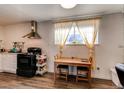 Compact kitchen featuring wooden table, chairs and modern black gas range at 6800 E Tennessee Ave # 461, Denver, CO 80224