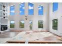 Spacious living room boasts high ceilings, fireplace, and an abundance of natural light from the many windows at 1810 Saddleback Dr, Evergreen, CO 80439