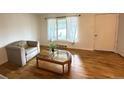 Relaxing living room with hardwood floors, a comfortable chair, and a large window for natural light at 260 Sheridan Blvd, Denver, CO 80226