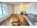 Bright living room featuring wood floors, a comfortable gray sofa, and natural light from a large window at 260 Sheridan Blvd, Denver, CO 80226