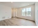 Living room showcasing wood floors, natural light, and a welcoming entryway at 702 N Bently St, Watkins, CO 80137