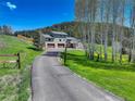 Long paved driveway leading to a beautiful home with a three-car garage and stunning mountain views at 20101 Spring Gulch Rd, Morrison, CO 80465