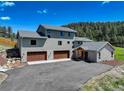 Home exterior boasts a three-car garage, stone accents, and a well-maintained driveway at 20101 Spring Gulch Rd, Morrison, CO 80465