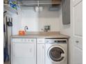 An efficient laundry area with side by side washer and dryer and storage is bright and clean at 277 N Broadway # 403, Denver, CO 80203