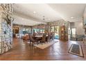 Spacious dining room features wood floors, stone walls, and a large window overlooking the outdoors at 142 Outpost Ln, Evergreen, CO 80439