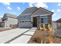 Inviting home featuring stone detailing, a two-car garage, and a landscaped front yard at 4478 Riviera Ct, Aurora, CO 80019