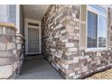 Up close view of the front entrance with decorative stone accents and a covered porch at 4478 Riviera Ct, Aurora, CO 80019