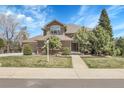 Charming two-story home with a well-maintained lawn and mature trees, creating a welcoming curb appeal at 3266 Coyote Hills Way, Castle Rock, CO 80109