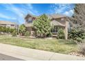 View of the home's exterior showcasing the architectural details and landscaping on a sunny day at 3266 Coyote Hills Way, Castle Rock, CO 80109