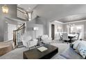 Elegant living room featuring a staircase, neutral decor, and plenty of natural light at 3266 Coyote Hills Way, Castle Rock, CO 80109