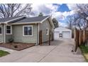 Exterior view of the house showcasing a long driveway leading to a detached garage with two garage doors at 4825 S Delaware St, Englewood, CO 80110