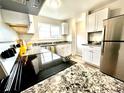 Modern kitchen featuring stainless steel appliances, granite countertops, and white cabinets at 7901 Newport St, Commerce City, CO 80022