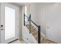 Bright entryway with modern staircase and a stylish frosted glass front door at 11400 W Grand Ave, Littleton, CO 80127
