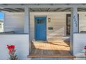 Inviting front porch with a blue door and wood flooring at 2222 Fenton St, Edgewater, CO 80214