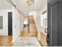 Bright entryway with hardwood floors, staircase, and modern lighting at 3322 N Columbine St, Denver, CO 80205