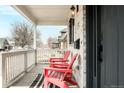 Inviting front porch featuring red Adirondack chairs and a stylish striped rug at 3322 N Columbine St, Denver, CO 80205