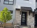 Modern townhome entrance with stone accents, black trim, and a welcoming front door at 2066 S Holly St # 3, Denver, CO 80222