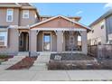 Inviting home exterior featuring a covered porch and attractive landscaping details at 7976 E 53Rd Dr, Denver, CO 80238