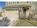 Front view of two-story home with stone and beige siding at 9638 Albion Ln, Thornton, CO 80229