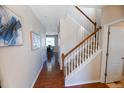 Inviting entryway with hardwood floors, white trim, staircase with wood handrail, and view into dining room at 3565 E 141St Dr, Thornton, CO 80602