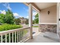 Cozy front porch with stone accents and a view of the neighborhood street at 3565 E 141St Dr, Thornton, CO 80602