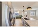 Bright kitchen with stainless steel appliances, quartz countertops and modern lighting at 3201 Albion St, Denver, CO 80207