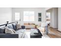 Bright living room with a comfortable sofa, stylish decor, and a glimpse into the adjacent bedroom with natural light at 3201 Albion St, Denver, CO 80207