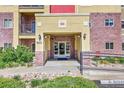Inviting entrance with brick accents, prominent building number, and well-maintained landscaping at 1044 Rockhurst Dr # 401, Highlands Ranch, CO 80129