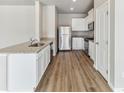 Bright kitchen features white cabinets, stainless steel appliances, granite countertops, and modern wood-look flooring at 819 Sunflower Dr, Brighton, CO 80601