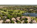Aerial view of homes and golf course, surrounded by lush green trees and a lake at 2535 W 115Th Dr, Westminster, CO 80234