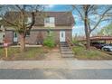Two story townhouse with brick facade, stairs to entry, and covered parking at 7755 E Quincy Ave # T48, Denver, CO 80209