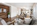Bright living room boasts modern wood accent wall, hardwood floors, and comfortable seating area at 1522 Willow St, Denver, CO 80220