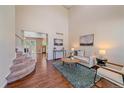 Bright living room with high ceilings, wood floors, a modern rug, and comfortable seating at 3528 Morning Glory Dr, Castle Rock, CO 80109