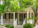 Close-up of the inviting front porch with white railings, black shutters, and charming details at 7899 E 28Th Pl, Denver, CO 80238