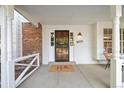 Inviting front porch with stylish security door, showcasing a 'hello' doormat and brick accents at 8035 S Garfield Way, Centennial, CO 80122